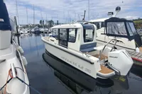2023 Nimbus Commuter 8 boat docked at marina, featuring sleek design and Mercury outboard engine.