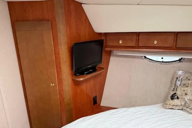  Yacht Photos Pics 2006 Rinker Fiesta Vee 410 cabin interior with TV, wood cabinetry, and bed.