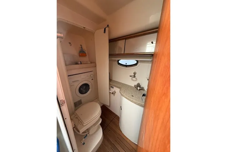  Yacht Photos Pics 2006 Rinker Fiesta Vee 410 bathroom with washer, toilet, sink, and storage cabinets.