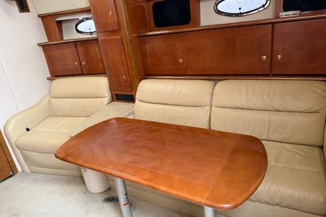  Yacht Photos Pics Interior of 2006 Rinker Fiesta Vee 410 yacht with leather seating and wooden table.