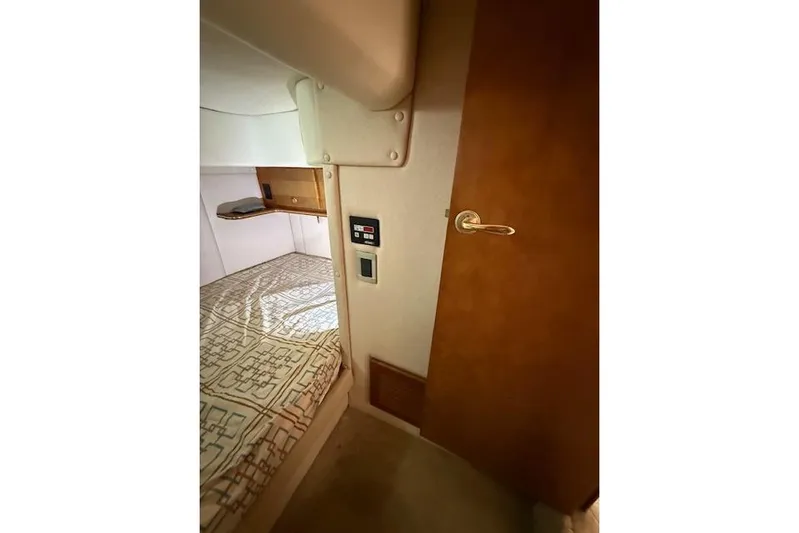  Yacht Photos Pics Interior cabin of 2006 Rinker Fiesta Vee 410 boat with bed and wooden door.