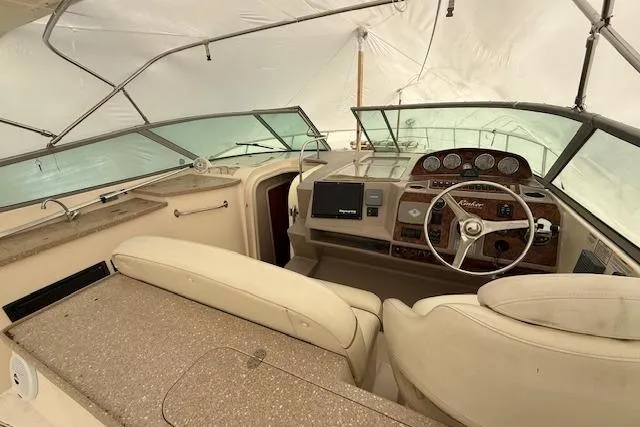  Yacht Photos Pics 2006 Rinker Fiesta Vee 410 boat interior with steering wheel and dashboard under cover.