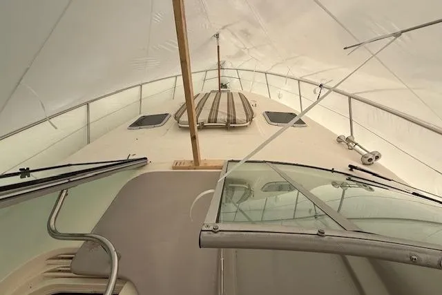  Yacht Photos Pics 2006 Rinker Fiesta Vee 410 boat under cover, showcasing deck and windshield.