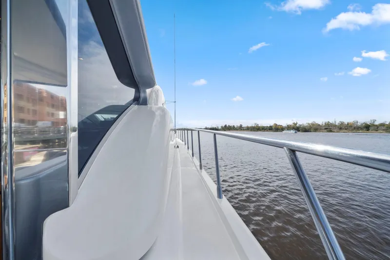 Double Down Yacht Photos Pics Side view of 2010 Mangusta 72 Express yacht on calm water under blue sky.