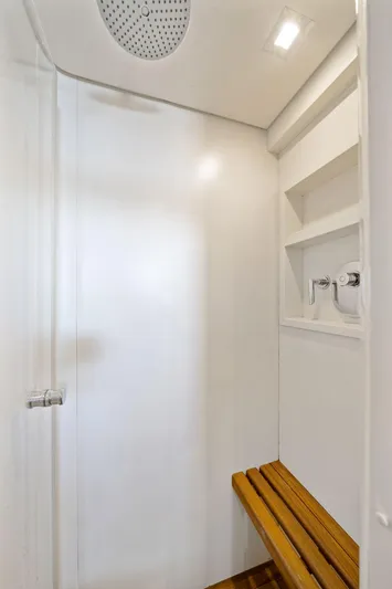 Double Down Yacht Photos Pics Shower area in 2010 Mangusta 72 Express yacht with wooden bench and modern fixtures.