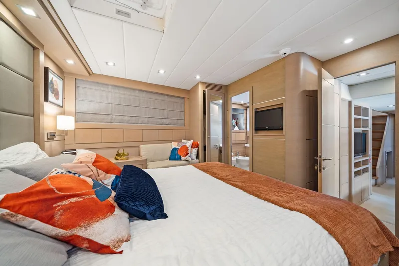 Double Down Yacht Photos Pics Luxurious bedroom interior of 2010 Mangusta 72 Express yacht with modern decor and vibrant pillows.