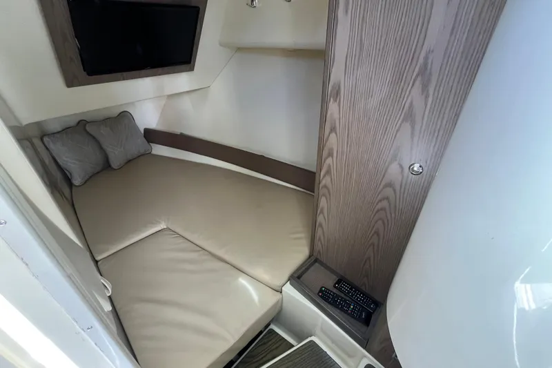  Yacht Photos Pics 2022 Chris-Craft Launch 35 GT I/O cabin interior with beige seating and TV.