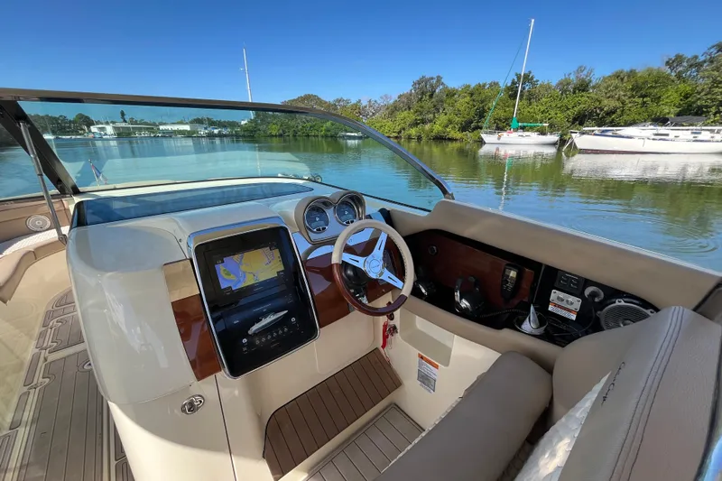  Yacht Photos Pics 2022 Chris-Craft Launch 35 GT I/O cockpit with navigation display, steering wheel, and serene water view.