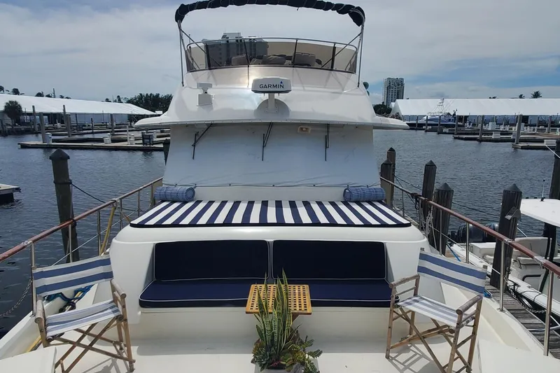 Ruby Yacht Photos Pics 1981 Hatteras 56 Motor Yacht with striped seating, docked at a marina.