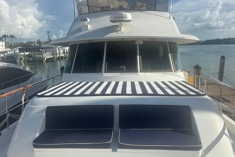 Ruby Yacht Photos Pics 1981 Hatteras 56 Motor Yacht docked, featuring striped sun pad and cushioned seating.