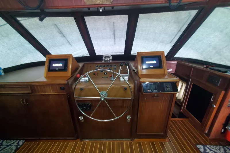 Ruby Yacht Photos Pics 1981 Hatteras 56 Motor Yacht helm with wooden dashboard and modern navigation screens.