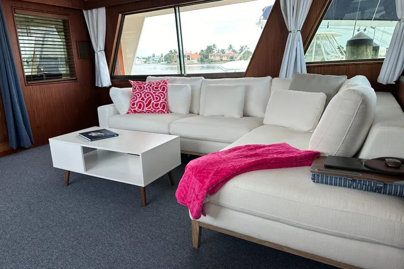 Ruby Yacht Photos Pics Luxurious interior of 1981 Hatteras 56 Motor Yacht with white sofa and vibrant decor.
