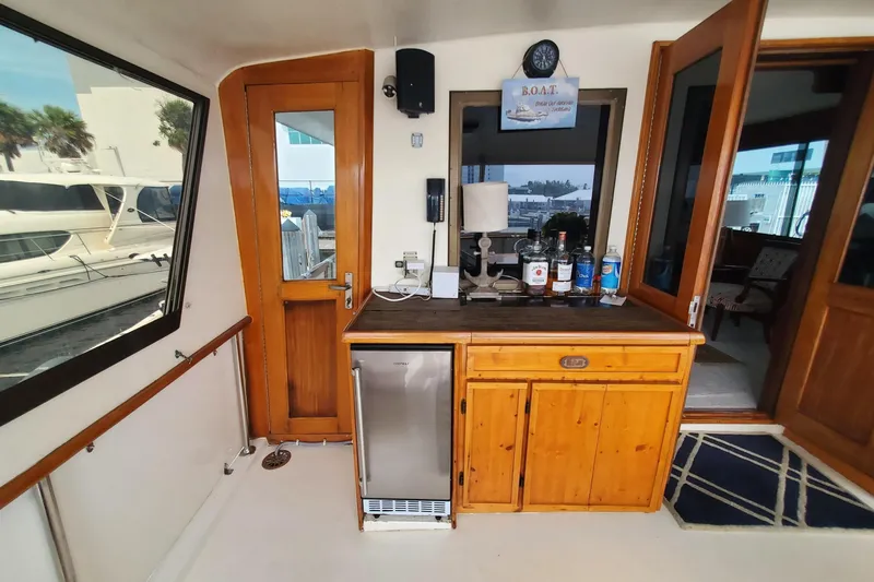 Ruby Yacht Photos Pics Interior of 1981 Hatteras 56 Motor Yacht with wooden cabinetry and mini fridge.