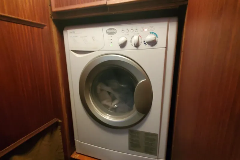 Ruby Yacht Photos Pics Washing machine inside 1981 Hatteras 56 Motor Yacht, surrounded by wooden cabinetry.