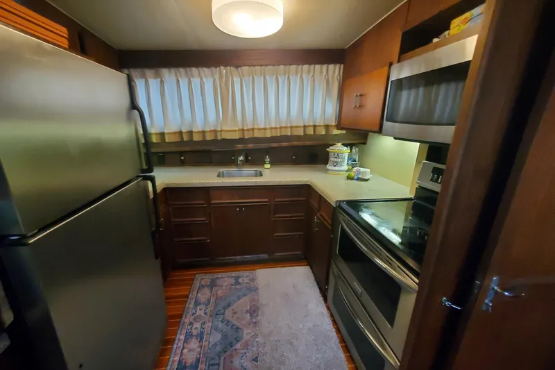 Ruby Yacht Photos Pics Cozy kitchen in 1981 Hatteras 56 Motor Yacht with modern appliances and wood cabinetry.