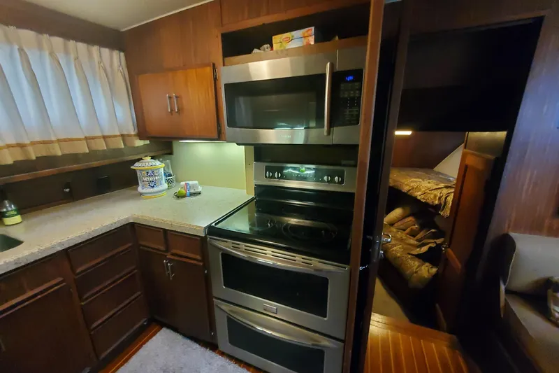 Ruby Yacht Photos Pics 1981 Hatteras 56 Motor Yacht kitchen with modern appliances and cozy cabin view.