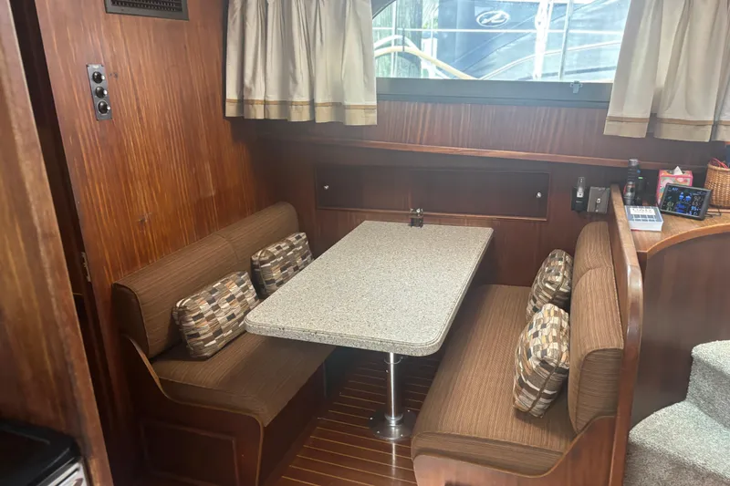 Ruby Yacht Photos Pics Cozy dining area in 1981 Hatteras 56 Motor Yacht with wood paneling and cushioned seating.