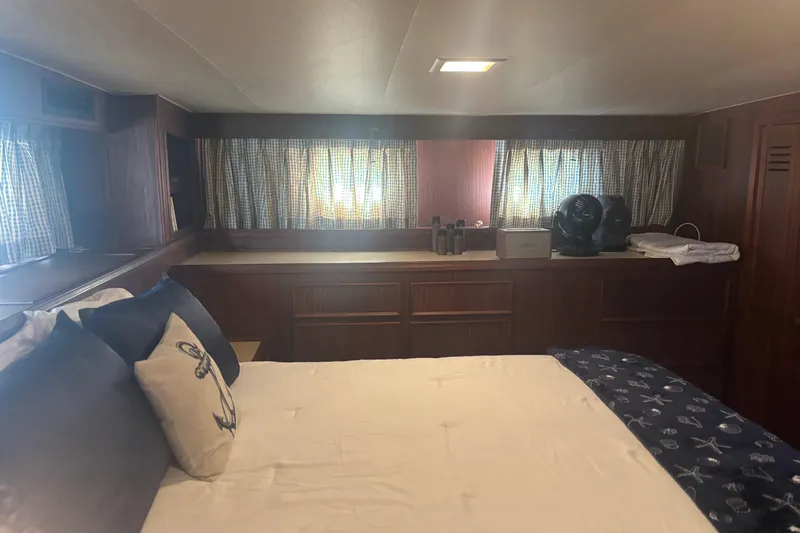 Ruby Yacht Photos Pics 1981 Hatteras 56 Motor Yacht bedroom with nautical decor and wooden cabinetry.