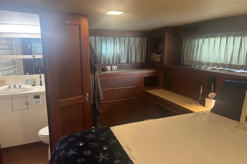 Ruby Yacht Photos Pics 1981 Hatteras 56 Motor Yacht interior with wood paneling, bed, and bathroom.