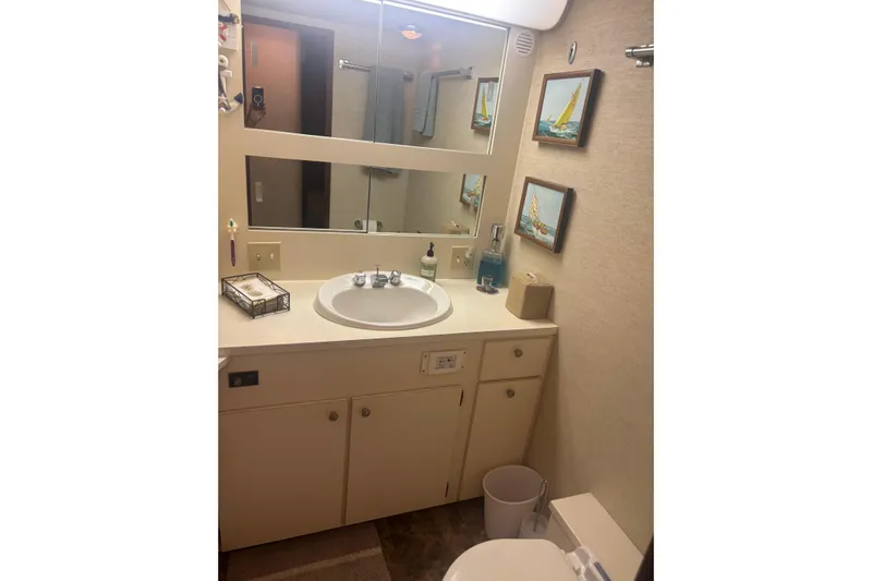 Ruby Yacht Photos Pics Bathroom interior of 1981 Hatteras 56 Motor Yacht with sink, mirror, and nautical decor.