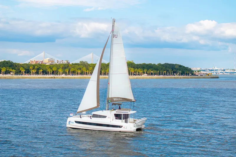 Cielo Yacht Photos Pics Sailing catamaran Bali 4.2, 2023 model, cruising on a scenic river with bridge view.