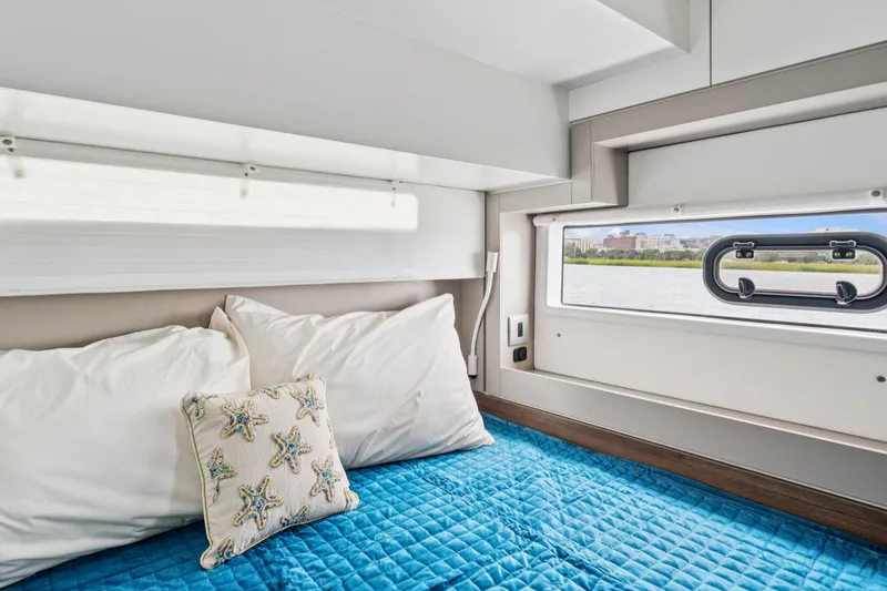 Cielo Yacht Photos Pics Cozy cabin interior of 2023 Bali 4.2 yacht with blue bedding and starfish pillow.