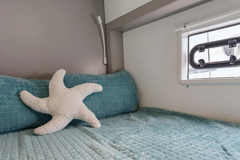 Cielo Yacht Photos Pics Cozy cabin bed in 2023 Bali 4.2 yacht with starfish pillow and window view.
