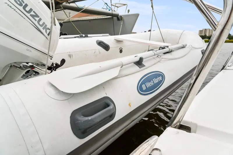Cielo Yacht Photos Pics Inflatable boat with Suzuki motor, West Marine logo, docked on water.