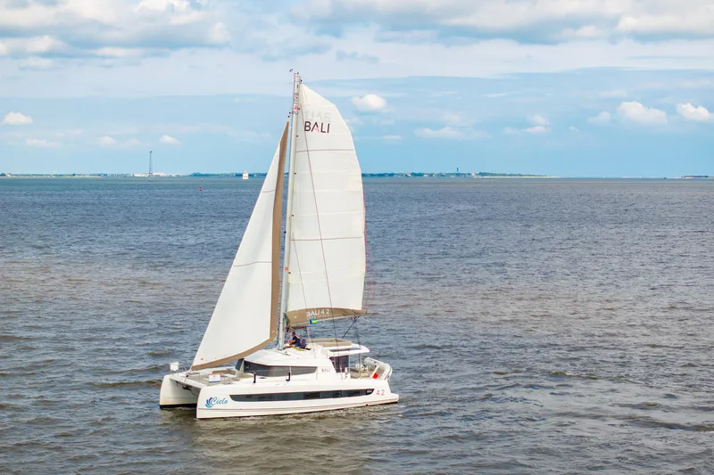 Cielo Yacht Photos Pics 2023 Bali 4.2 catamaran sailing on open sea under a partly cloudy sky.