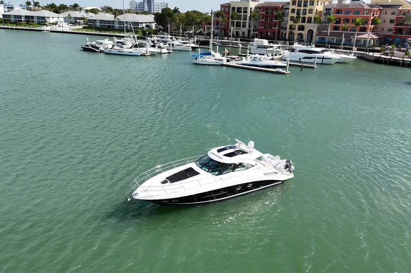  Yacht Photos Pics 2014 Sea Ray 470 Sundancer yacht cruising near marina with docked boats.