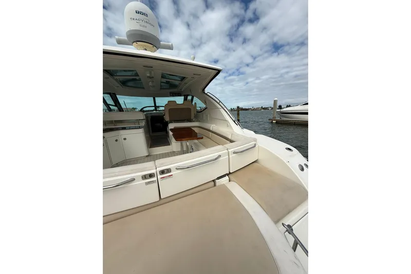  Yacht Photos Pics 2014 Sea Ray 470 Sundancer yacht interior with seating and table, docked by the water.
