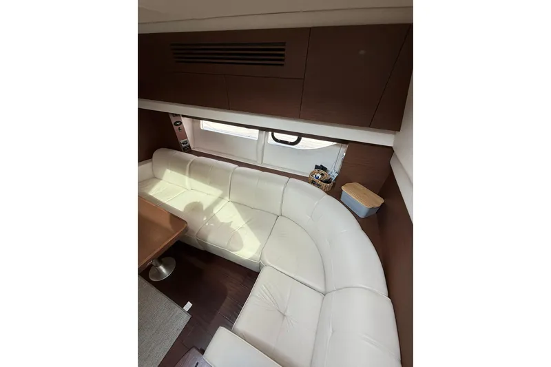  Yacht Photos Pics Luxurious interior of 2014 Sea Ray 470 Sundancer with white leather seating and wooden accents.
