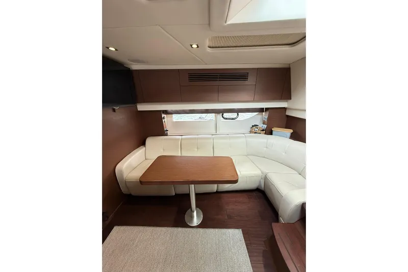  Yacht Photos Pics Luxurious interior of 2014 Sea Ray 470 Sundancer with white leather seating and wooden table.