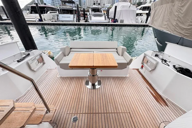  Yacht Photos Pics 2025 Ferretti Yachts 500 deck with seating and table, docked at marina.