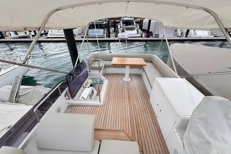  Yacht Photos Pics 2025 Ferretti Yachts 500 flybridge with seating, table, and helm, docked at marina.