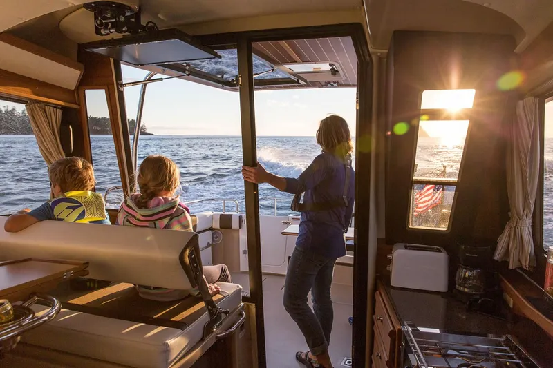  Yacht Photos Pics Interior view of 2025 Ranger Tugs R-29 CB boat with passengers enjoying sunset.