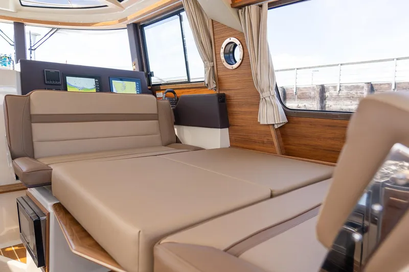  Yacht Photos Pics 2025 Ranger Tugs R-29 CB interior with convertible seating and modern navigation displays.