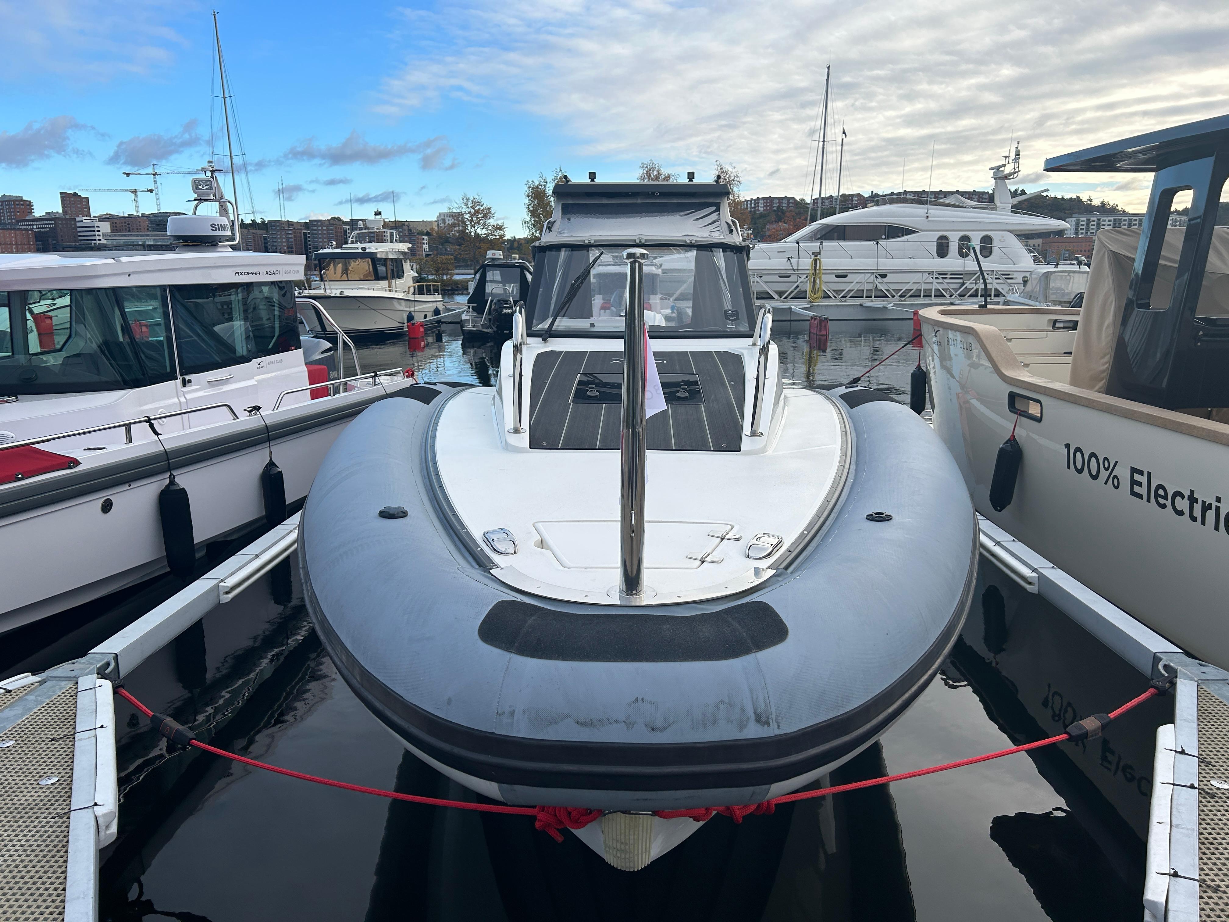 Agapi 950 boat, 2018 model, docked at marina with other vessels, under a partly cloudy sky.