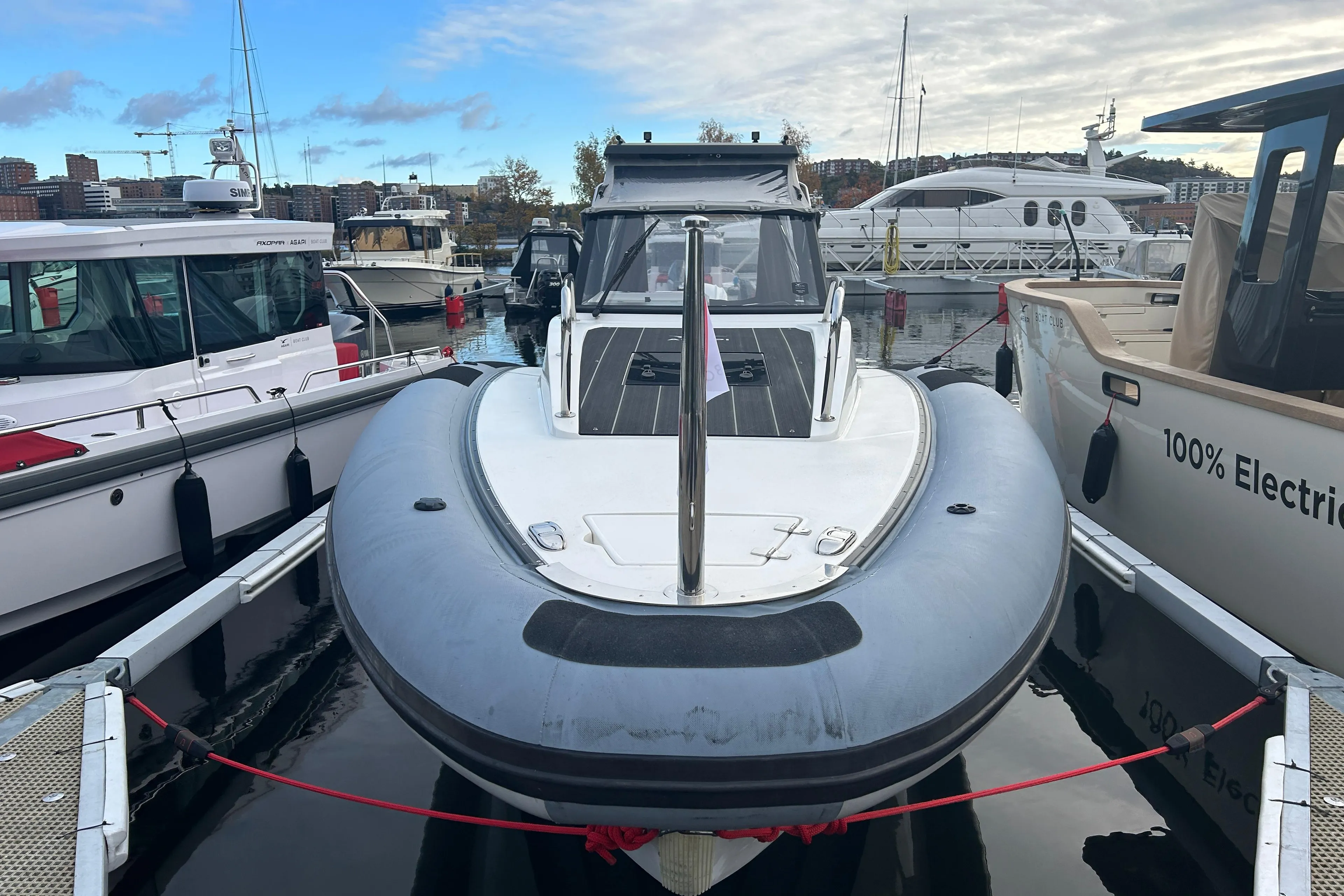 Agapi 950 boat, 2018 model, docked at marina with other vessels, under a partly cloudy sky.