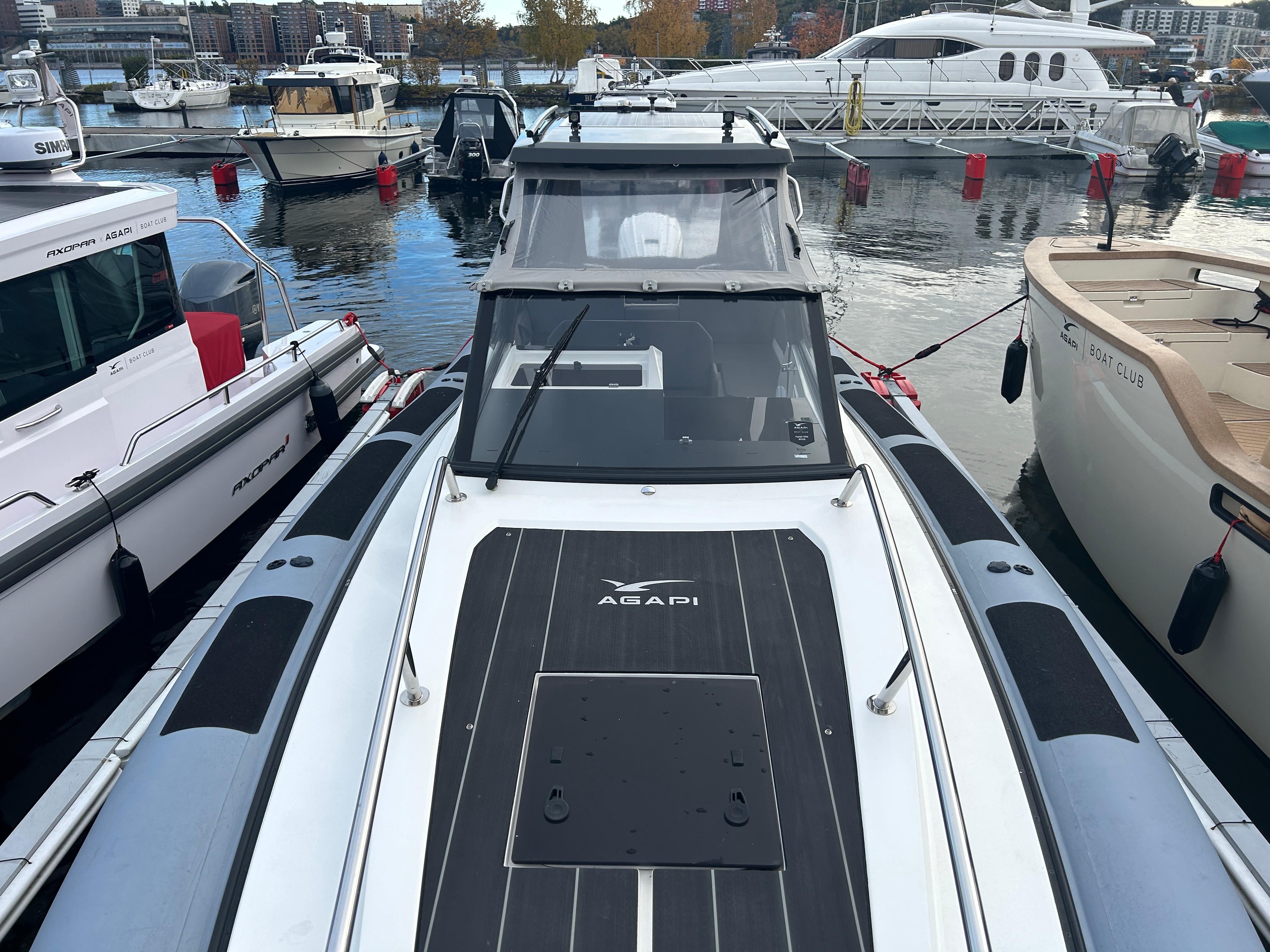 Agapi 950 boat, 2018 model, docked among other boats in a marina setting.