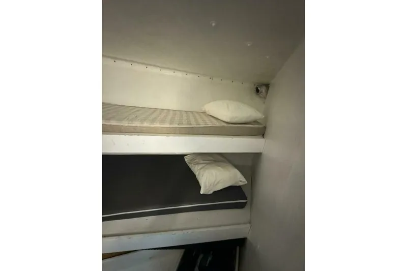 Annabel C Yacht Photos Pics Bunk beds inside a 1987 Monroe Custom 52, featuring simple mattresses and pillows.