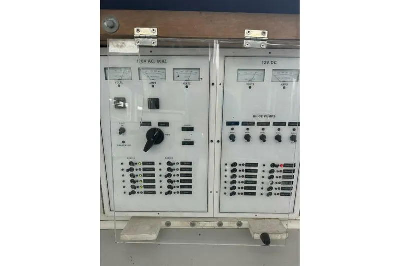 Annabel C Yacht Photos Pics Electrical control panel of a 1987 Monroe Custom 52 boat, featuring volt, amp, and hertz meters.