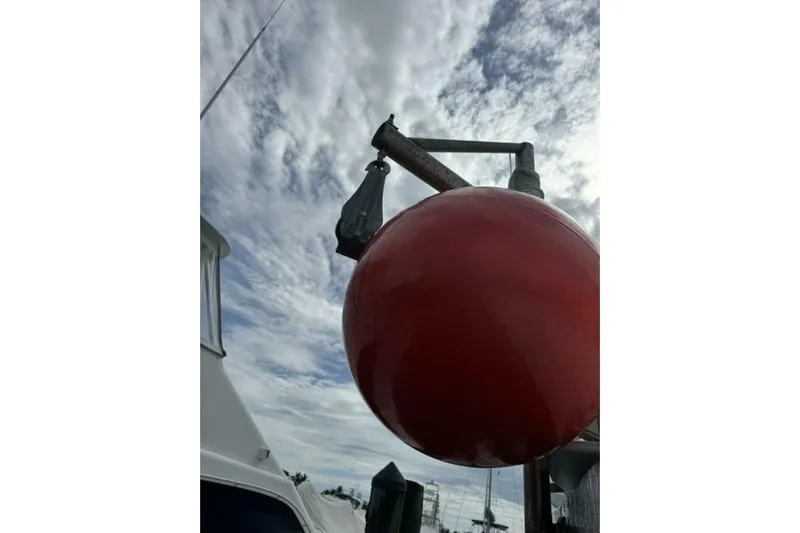 Annabel C Yacht Photos Pics Red buoy on a boat with cloudy sky, Monroe Custom 52, 1987.