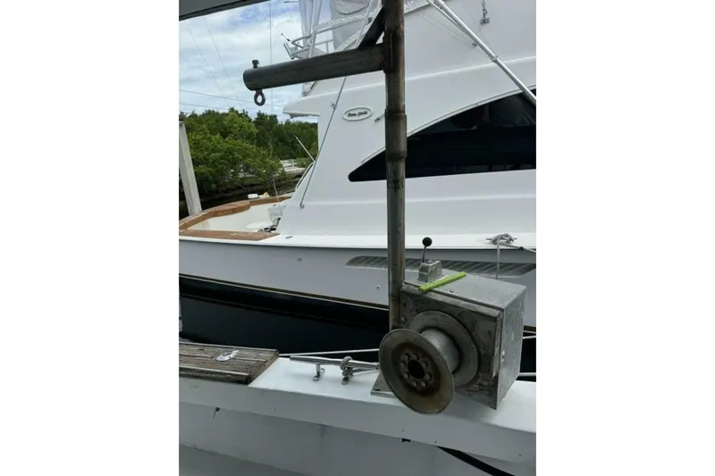 Annabel C Yacht Photos Pics Fishing equipment on a 1987 Monroe Custom 52 boat, docked near greenery.