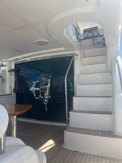  Yacht Photos Pics 2005 Neptunus 62 Flybridge yacht interior with stairs and seating area.