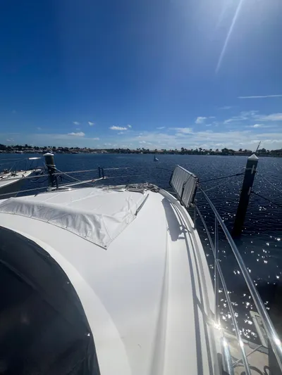  Yacht Photos Pics 2005 Neptunus 62 Flybridge yacht on a sunny day, overlooking calm waters.