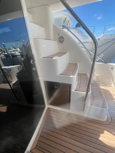  Yacht Photos Pics 2005 Neptunus 62 Flybridge yacht with teak steps and stainless steel railing.