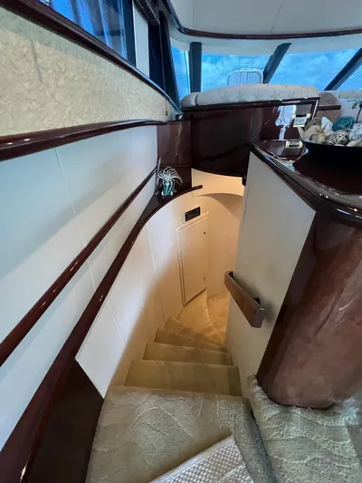  Yacht Photos Pics Interior staircase of 2005 Neptunus 62 Flybridge yacht with elegant wood finish.