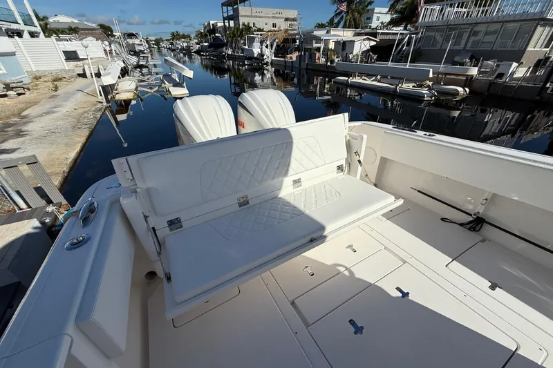  Yacht Photos Pics 2014 Intrepid 327 Center Console boat with seating, docked in a serene marina.