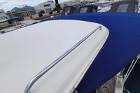 Boat deck with blue and white cover, Sas-Vektor 950, 2015 model, marina background.